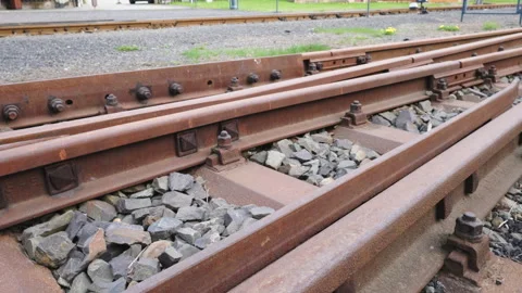 Rusty old railway tracks at the train station connected by big bolts Stock Footage 272773470