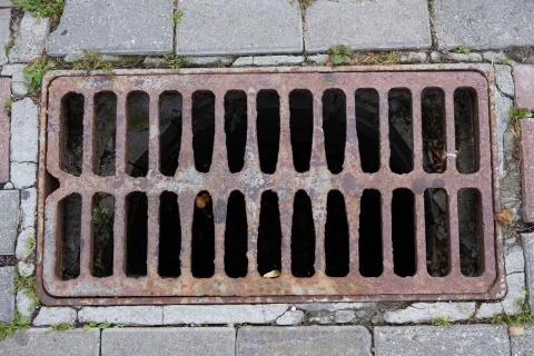 Rusty old rectangular sewer grate Stock Photos
