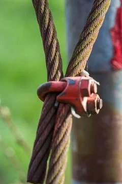  rusty old steel cable of a former barrier covered with moss rusty old ste... Stock Photos