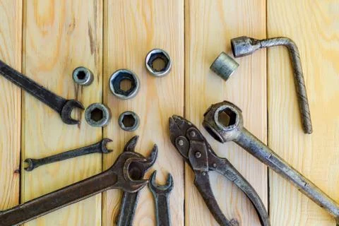 Rusty old tools are laid out on a wooden background Stock Photos