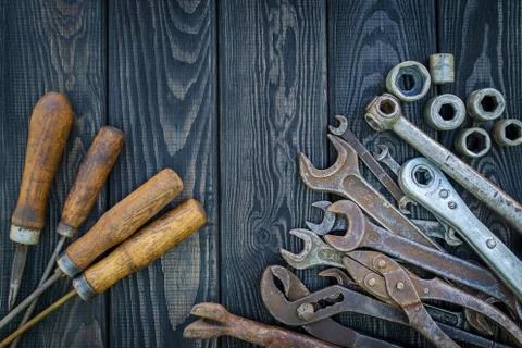 Rusty Old Tools on black vintage wood background. Stock Photos