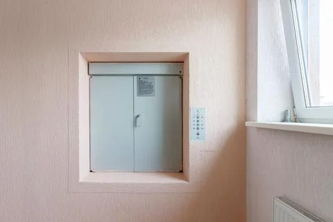 A rusty old transport elevator in the wall is opened Fotos de archivo