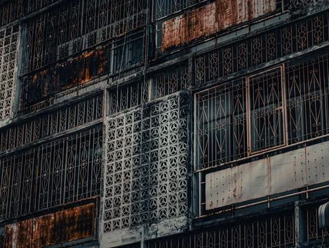 Rusty Ornate Iron Window Grille Patchwork Pattern, Weathered Metal Security.. 库存照片