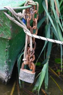Rusty padlock and chain on green metal surface Stockfoto's
