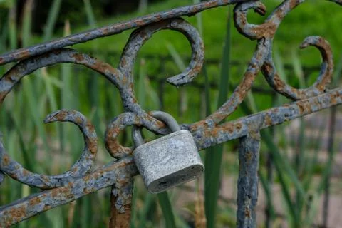 A rusty padlock hangs on the bridge. Stock Photos