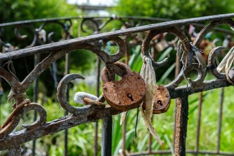 A rusty padlock hangs on the bridge. Foto stock