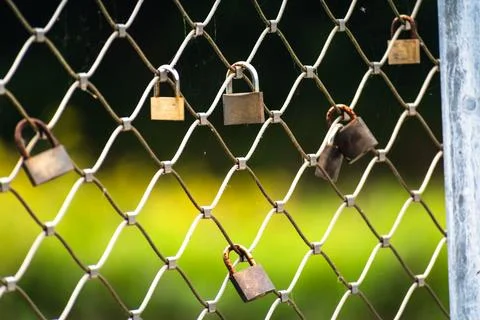 Rusty padlocks attached to the metal railing of a bridge, tradition of padl.. Stockfoto's