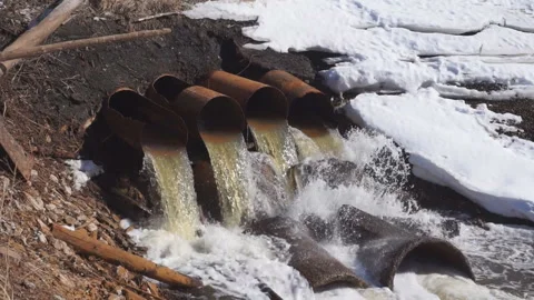 Rusty pipe industrial liquid waste into river . Video stock 95033423