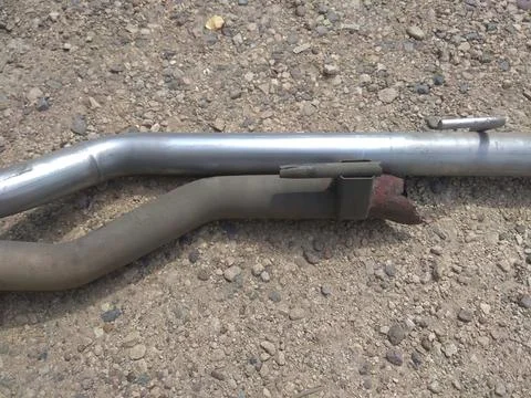 A rusty pipe is laying on the ground.  Stock Photos