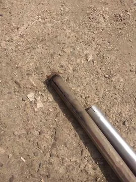 A rusty pipe is laying on the ground. Foto stock