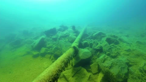 Rusty pipe underwater at old quarry filled by water Stock Footage 156792879