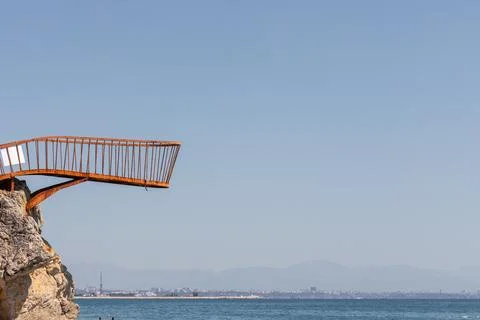 Rusty Platform on Cliff Overlooking Sea and Distant City Stock Photos