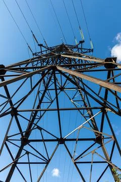 Rusty power line is on the blue sky background. Vertical Stock Photos