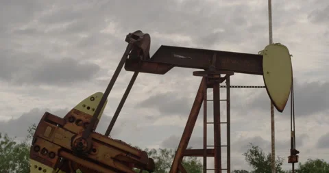 A rusty pump jack pumping oil in a remote place Video stock 149349862