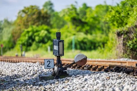 Rusty Railroad Switch Lever And Signal Near Tracks In Green Countryside Lan.. Stock Photos