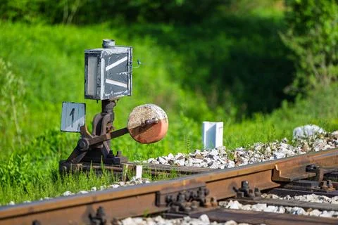 Rusty Railroad Switch Lever And Signal Near Tracks In Green Countryside Lan.. Stock Photos