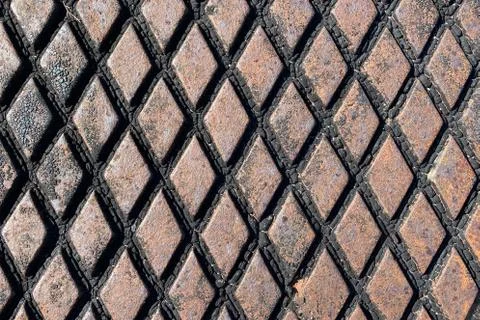 Rusty retro close-up view diamond plate storm drain cover Stock Photos