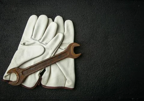Rusty retro key on the background of work gloves, metal, work gloves, rusty Stock Photos