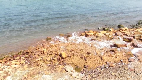 Rusty river water flowing into a blue bigger river Stock Footage 337623615