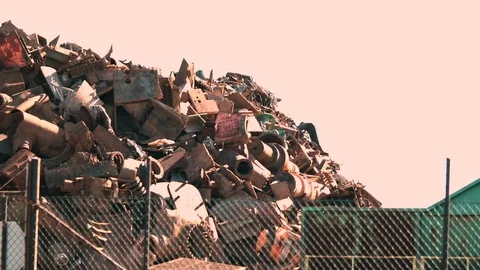 Rusty scrap metal in a heap through a fence Stock Footage 96085703