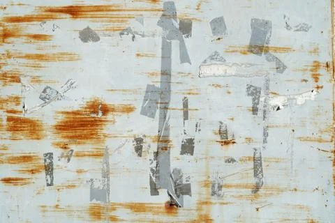 Rusty scratches and marks from labels and stickers on grey painted metal wall Stock Photos