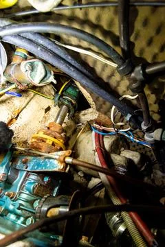 Rusty shaft coupling with hoses inside boat compartment Foto stock