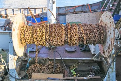 Rusty ship chain is wound on a large metal coil Stock Photos