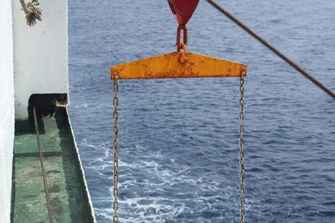 Rusty Ship Lifting Bar and Chains Above Open Ocean 스톡 사진