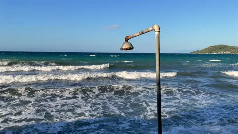 Rusty shower over ocean with waves breaking on shore Stockbeeldmateriaal 287304166
