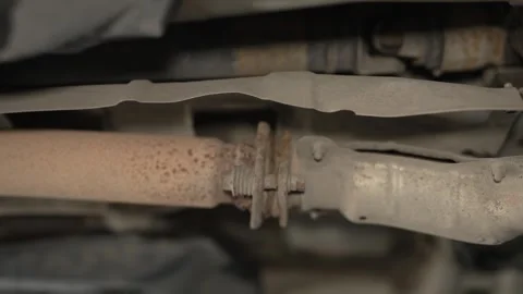 A rusty spring-loaded flange joint connecting parts of a car exhaust pipe. Stock Footage 340978105