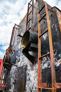 Rusty steam train details under a cloudy sky in a vintage railway yard Stock Photos