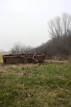 Rusty steamroller lying next to a cultivated field on a misty day in winter Stock Photos