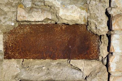 Rusty steel embedded plate in brick wall white yellow green shades of colors Stock Photos