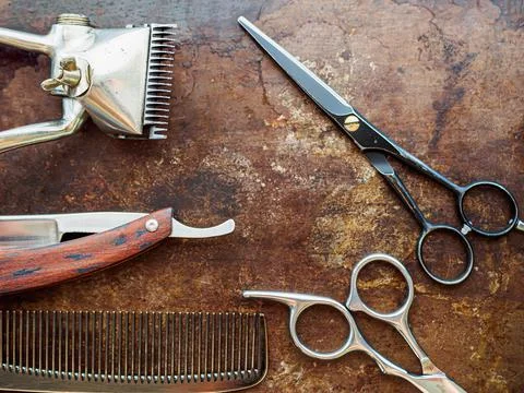 On a rusty surface are old barber tools. Vintage manual hair clipper comb raz Stock Photos