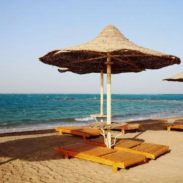 Rusty textured beach umbrellas on the empty beach in the morning Stock Photos