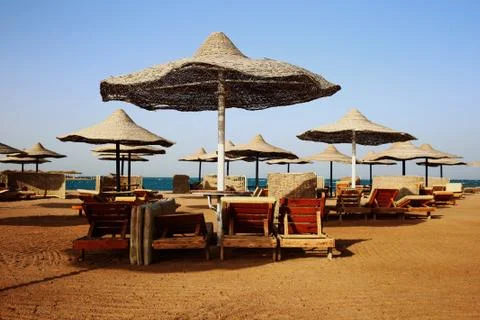 Rusty textured beach umbrellas on the empty beach in the morning Stock Photos