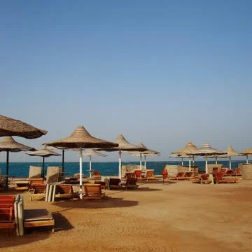 Rusty textured beach umbrellas on the empty beach in the morning Stock Photos