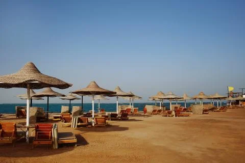 Rusty textured beach umbrellas on the empty beach in the morning Stock Photos
