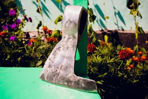 Rusty tip of sharp ax lies on edging boards Foto stock