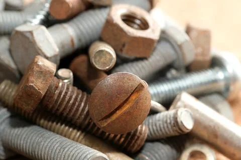 Rusty tools and fasteners form a textured array on wood Stock Photos