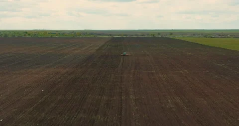 Rusty tractor is plowing land, view from drone of agricultural fields in seeding Stock Footage 197692345