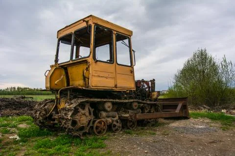 Rusty tractor on tracks in the field. Stock Photos