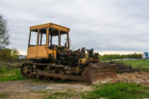 Rusty tractor on tracks in the field. Stock Photos