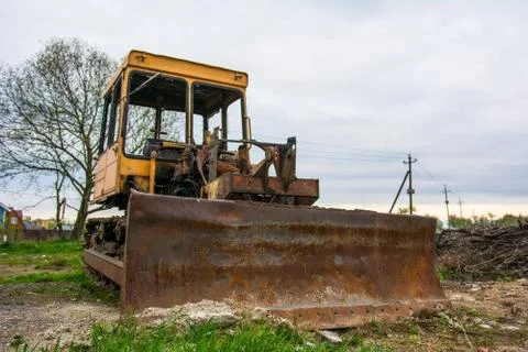 Rusty tractor on tracks in the field. Stock Photos