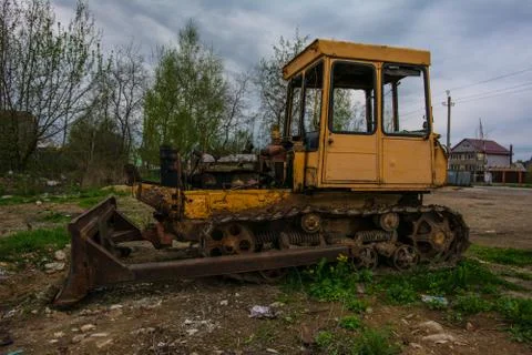 Rusty tractor on tracks in the field. Stock Photos