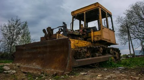 Rusty tractor on tracks in the field. Stock Photos