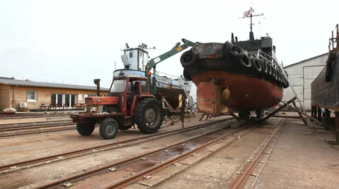 A rusty tractor working on rusty barge Stock Footage 40687394