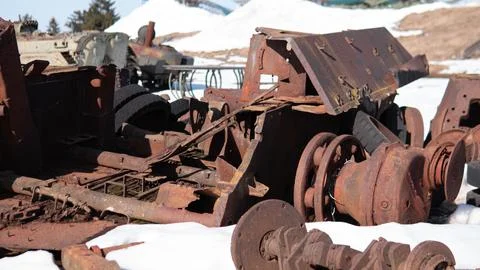 Rusty train wheelset and corroded undercarriage resting on snowy ground in 스톡 사진