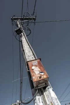 Rusty Utility Pole with Power Lines Against Blue Sky Stock Photos