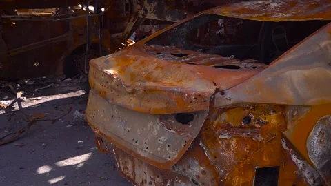 Rusty vehicle parked on roadside, blending with metal and asphalt surroundings Stock Footage 274572059